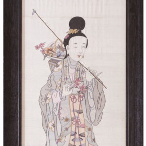 Framed textile art depicting a standing female figure in pale gray and pink robes holding flowers.