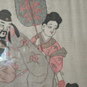 Textile depicting stylized figures, flowers, and a fan, rendered in dusty pink, gray, black, and gold threads.