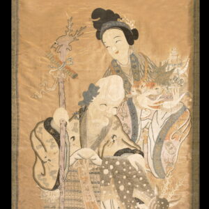 An intricate embroidered textile scroll featuring a smiling old man, a young woman, and a spotted fawn.