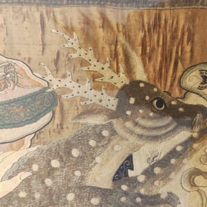 Detailed embroidery shows a spotted deer and antlers against a gold background with teal and cream figurative accents.