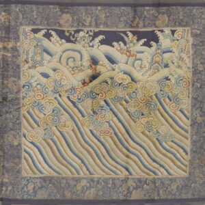 Muted blue and gold textile displaying stylized ocean waves, foam, and cloud motifs within a patterned border.