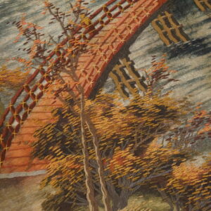 Close-up of a textured scenic rug depicting an autumn bridge and thick yellow and orange trees.