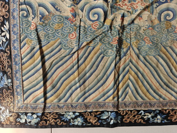 Wavy blue and gold diagonal pattern with swirling cloud motifs and a black embroidered floral and knotwork border.