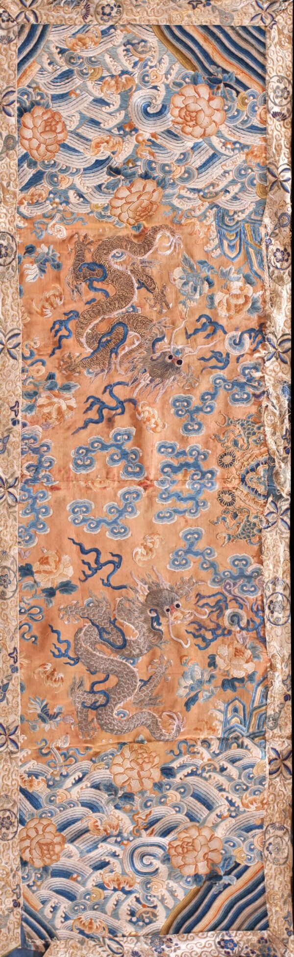 Golden-orange embroidered textile featuring a detailed dragon, blue clouds, and gold and white floral patterns.