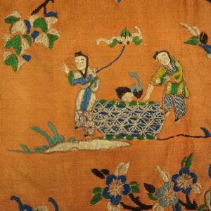 Highly textured orange rug featuring intricate embroidery of two figures and blue and white geometric forms.