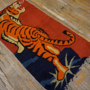 Orange, tan, and black tiger rug on a red and navy background resting on rustic wood floors.