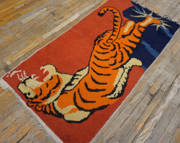 Low-pile runner with a vibrant orange tiger pattern and navy accents on distressed gray wood planks.