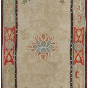 Beige rug featuring a faded botanical pattern, a coral and blue central medallion, and wide patterned borders.