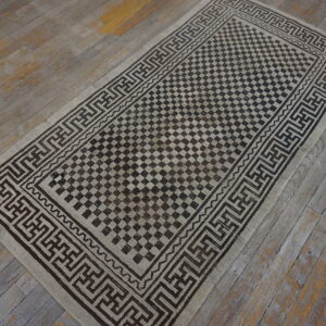 Low-pile runner with a checkered dark brown and tan design on distressed wooden planks.