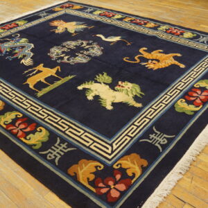 Dark blue rug with deer, tiger, and dragon patterns, detailed floral border, resting on wood planks.