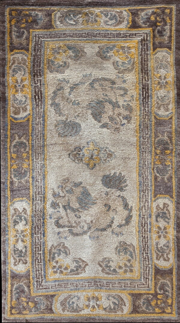 Plush rug with a thick brown border and abstract central design in beige, muted gold, and blue.