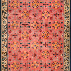 Close-up of a high pile rug in rust, navy, gold, and teal with a visual tag attached near a folded edge.