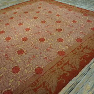 Low-pile rug in rust, gold, and mauve with intricate repeating floral patterns on worn wood floor.