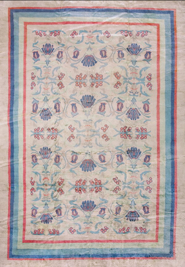 Distressed low pile rug displaying stylized blue, teal, and coral floral motifs on a light beige ground.