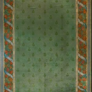 Green rug with floral border design.