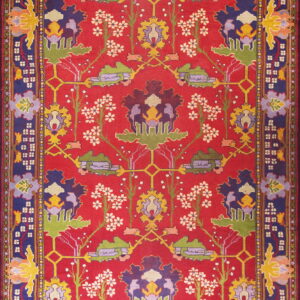 Vibrant red rug with a navy border framing yellow, green, and purple intricate botanical motifs.