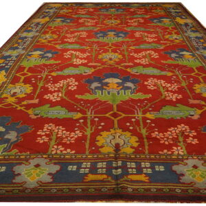 Red runner rug with blue, yellow, and green stylized floral and botanical designs.