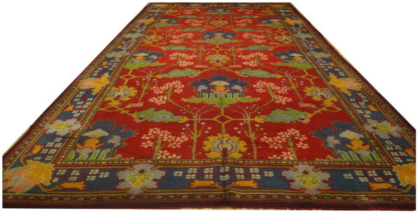 Red runner rug with blue, yellow, and green stylized floral and botanical designs.