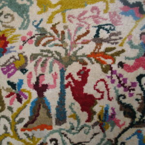 Multi-colored, high-pile rug detail showing stylized figures, red animals, and floral patterns on a cream background.