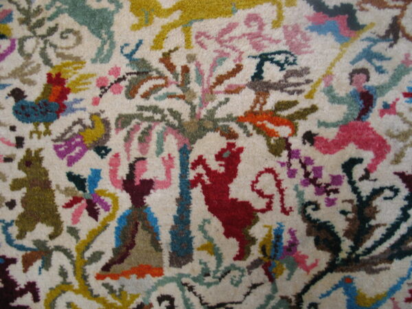 Multi-colored, high-pile rug detail showing stylized figures, red animals, and floral patterns on a cream background.