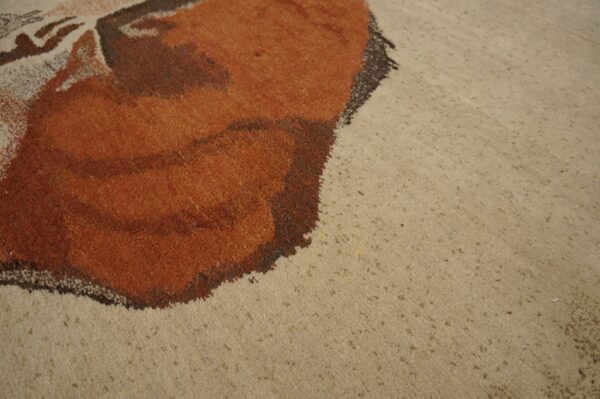 Expressive vintage ecuadorian pictorial art rug from ecuador 8 Detail view of a rug showing rusty orange shapes against a textured beige background.