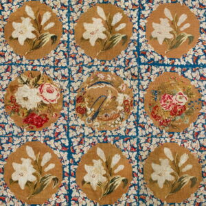 Detailed, low-pile rug with tan floral medallions, featuring lilies and roses, on a dense blue leafy field.