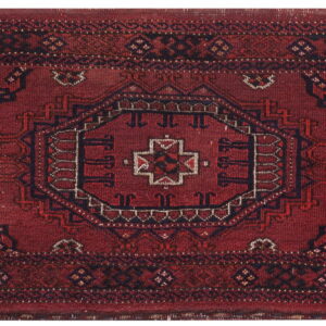 Red runner rug featuring traditional geometric patterns in dark blue, black, and tan accents.