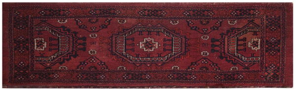 Deep red runner rug with a tribal geometric pattern highlighted by dark blue and off-white details.
