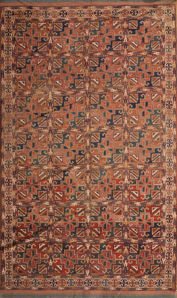 Geometric rug featuring a grid of squares with complex star-like motifs in red, navy, teal, and tan tones.