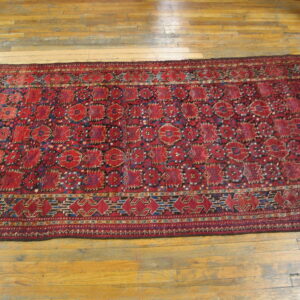 Low-pile red and blue geometric runner rug placed on bright natural hardwood floor planks.