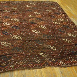 Red-brown rug featuring geometric patterns and contrasting cream and navy accents on wood flooring.