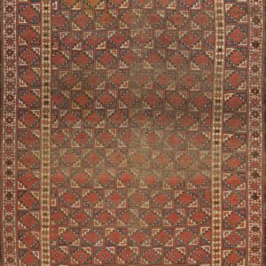 A distressed rust and navy geometric rug with repeating diamonds and complex stepped borders.
