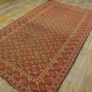 Red, tan, and blue geometric rug rests on wide, rustic wood planks.