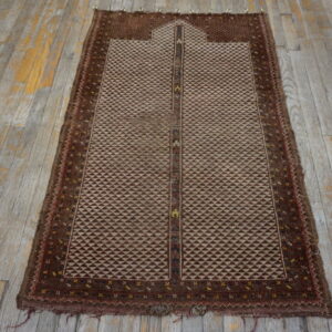 Geometric brown and beige rug with a framed mihrab design shown on worn wooden flooring.