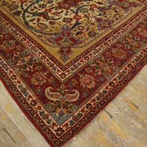 Intricate red and gold floral rug border on a distressed light wood plank floor.