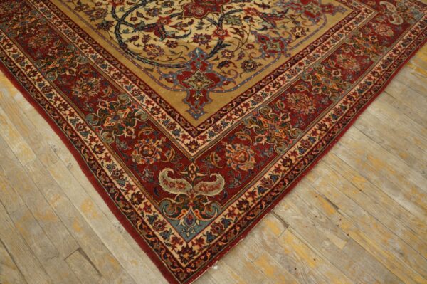 Intricate red and gold floral rug border on a distressed light wood plank floor.