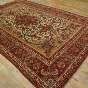 Tan rug with intricate red and blue floral medallions and borders sits on distressed wood floor.