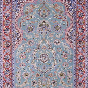 Blue traditional rug with intricate floral designs, a central medallion arch, and detailed red borders.
