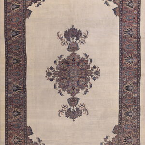 A traditional cream rug with a rose and blue central medallion and matching detailed borders.