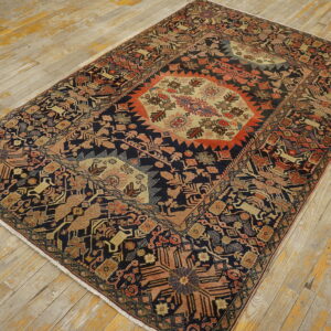 Navy tribal rug with stylized animal motifs and a central beige medallion rests on rustic wood planks.