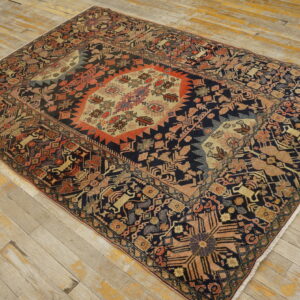 A multicolored rug with a geometric medallion pattern rests on distressed light wood floors.