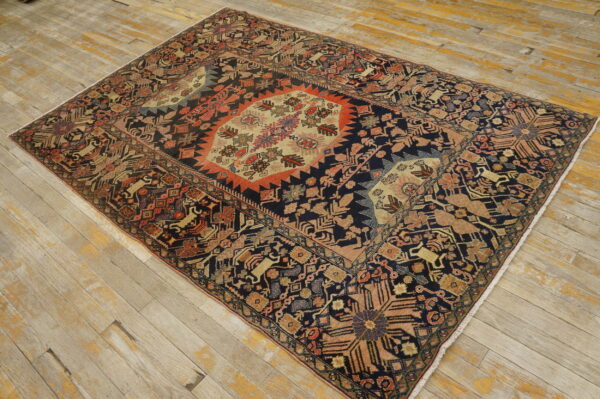A multicolored rug with a geometric medallion pattern rests on distressed light wood floors.