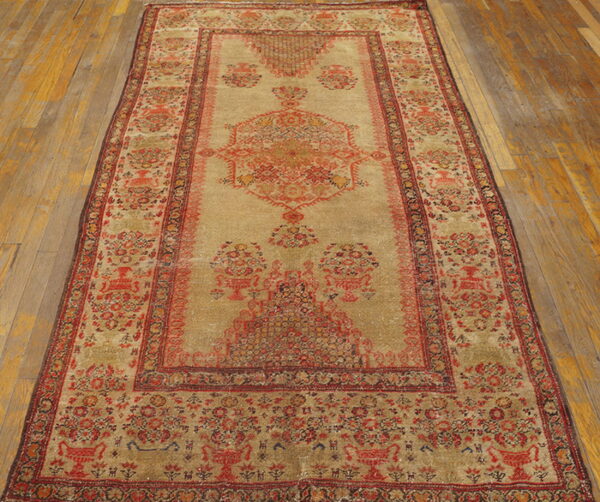 Detailed beige and reddish traditional rug runner with low pile placed on light brown wood flooring.