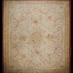 Muted ivory rug featuring a formal floral and scrolling vine pattern in faded pink and tan tones.