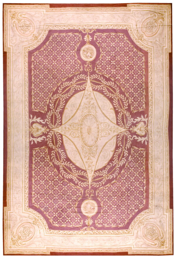 Mauve and ivory traditional rug with a central medallion, ornate lattice field, and foliage borders.