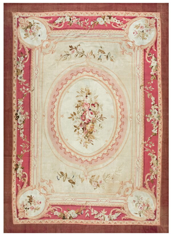 Low pile rug featuring a cream field and decorative pink floral borders and central medallion.