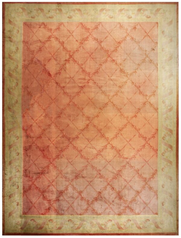 Faded coral rug with a subtle floral trellis pattern and wide distressed beige border design.