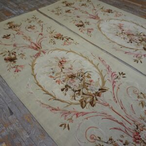 Pair of flat runners featuring scrolling floral bouquets in pastel colors on distressed wooden floorboards.