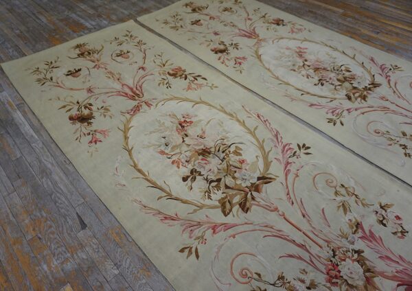 Pair of flat runners featuring scrolling floral bouquets in pastel colors on distressed wooden floorboards.