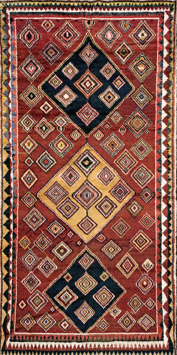 Textured burgundy rug featuring a complex geometric design of nested diamonds in black, gold, and accent colors.